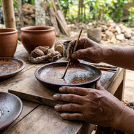 Artisan hand-decorating a Cerita batik pattern plate in the Sanggarpeni workshop