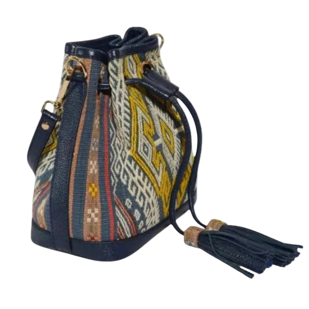 Handwoven Nusa Tenggara songket mini bucket bag in navy and gold with leather trim and drawstring closure
