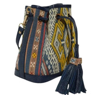 Side view of the songket mini bucket bag showing the handwoven fabric panel